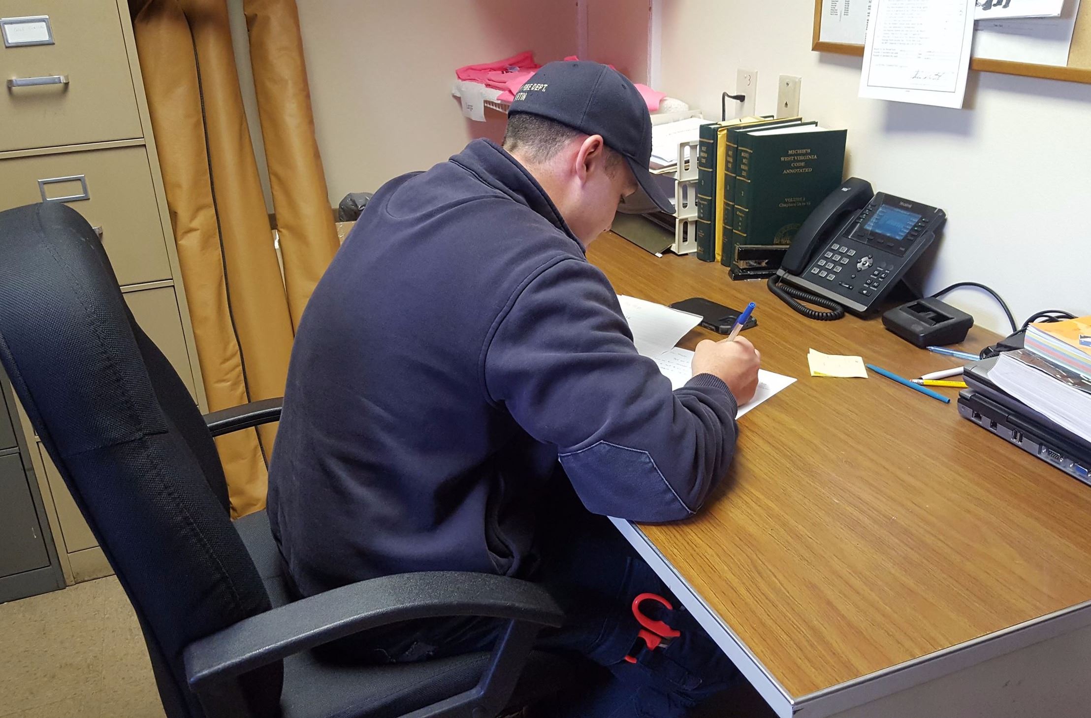 Weirton firefighter Phil Martin works on a letter to the Firefighters Pen Pal Club